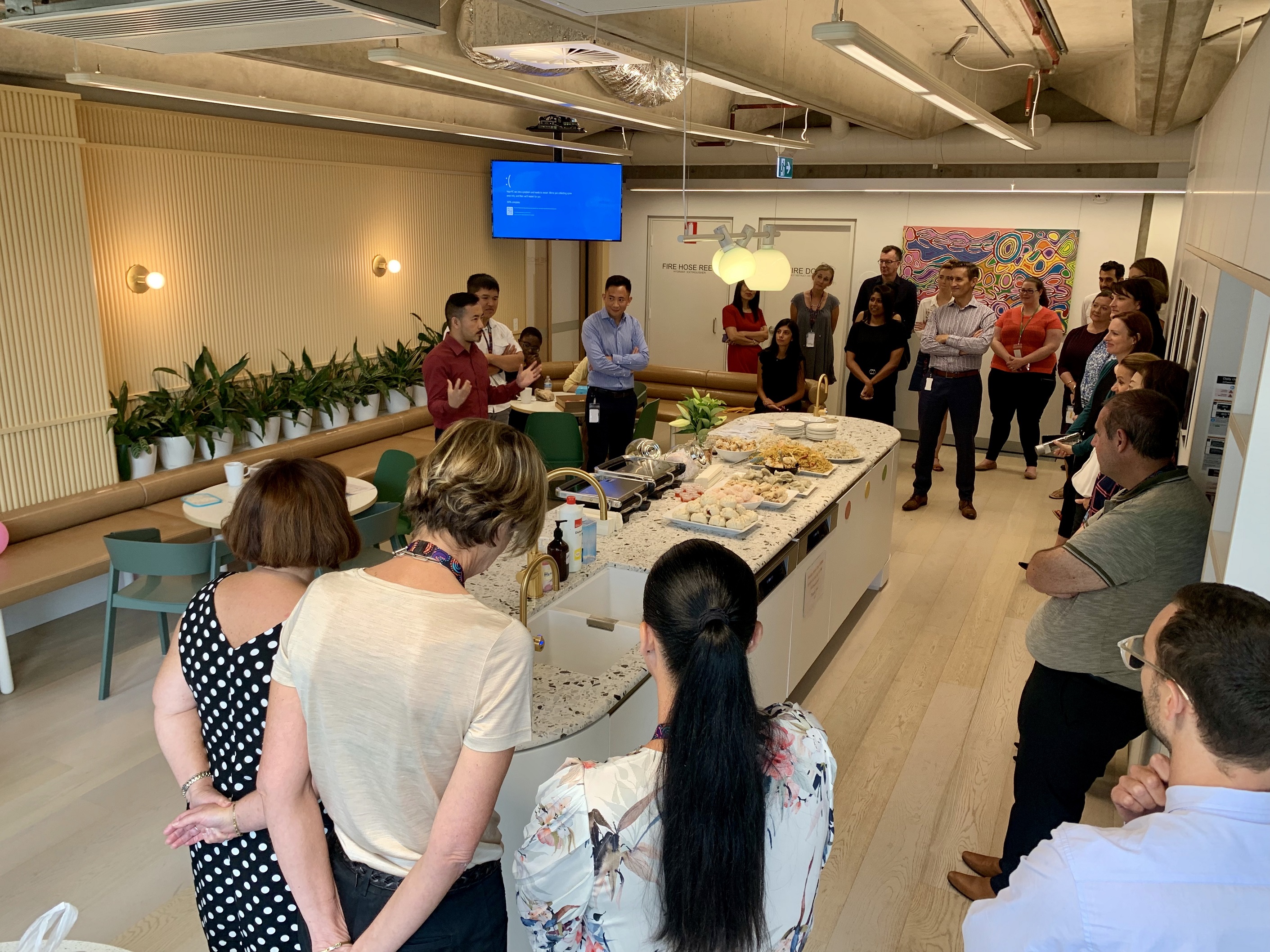 employees standing in the kitchen for a culture presentation